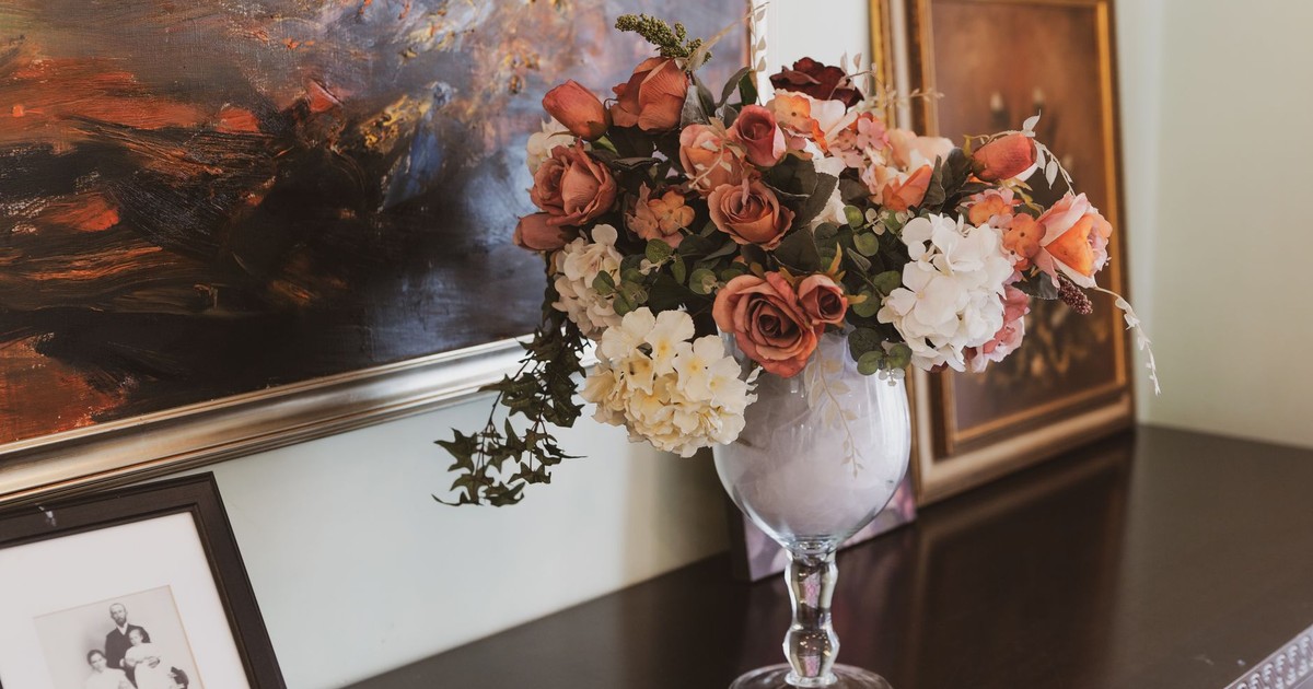 Beautiful floral arrangement in a vase against a backdrop of artistic paintings, perfect for sophisticated decor.