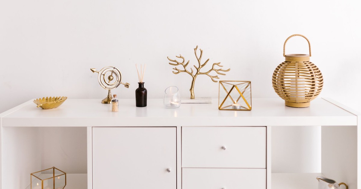 Sleek white cabinet with elegant gold decorations on a modern white background