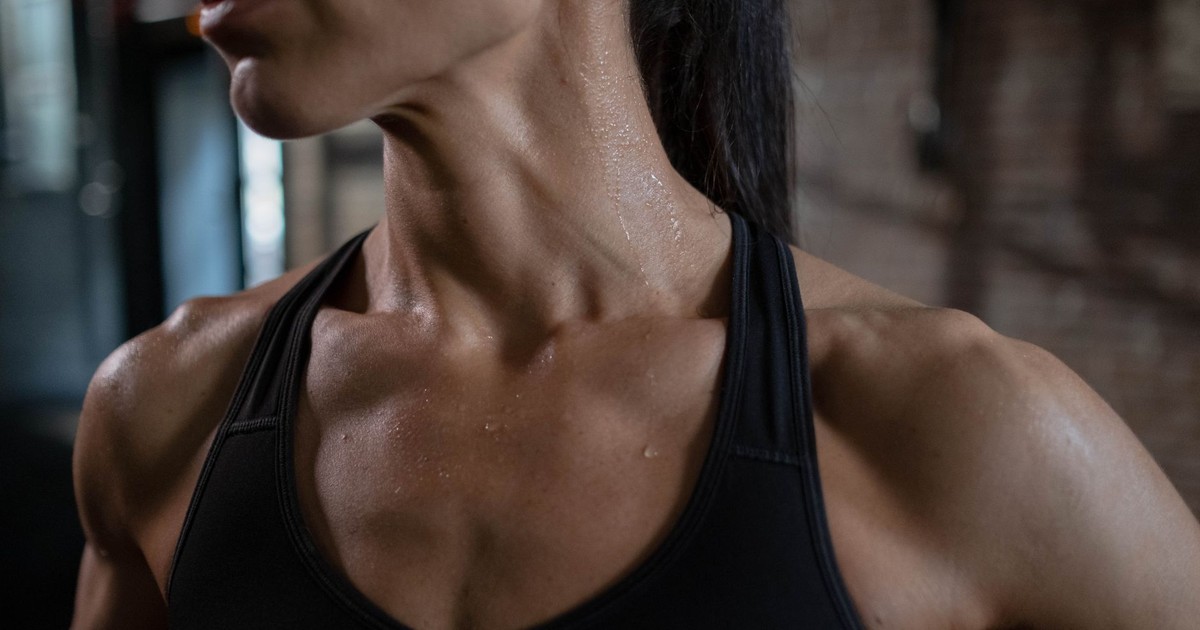 Close-up of a fit and muscular woman sweating post-workout, highlighting strength and fitness.