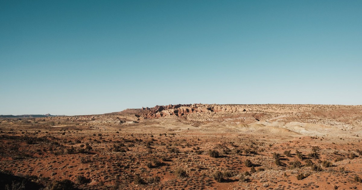 Expansive desert landscape in Utah with clear blue skies, showcasing natural beauty.