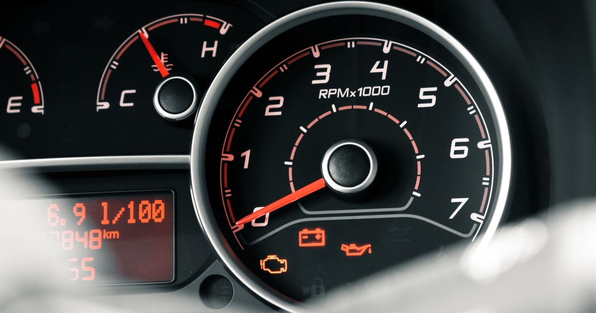 Detailed view of a car dashboard featuring tachometer, odometer, and various indicators.