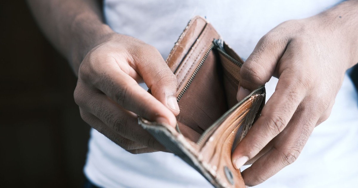 Close-up of hands holding an empty wallet, highlighting financial struggles and economic crisis.