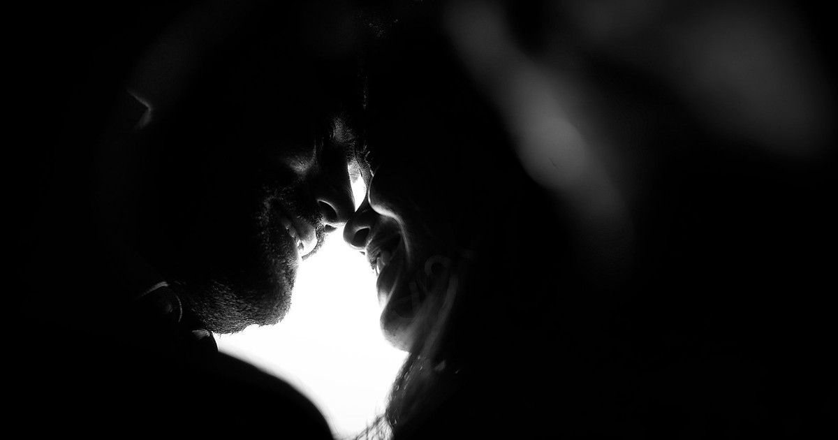 A captivating black and white silhouette of a romantic couple sharing an intimate moment.