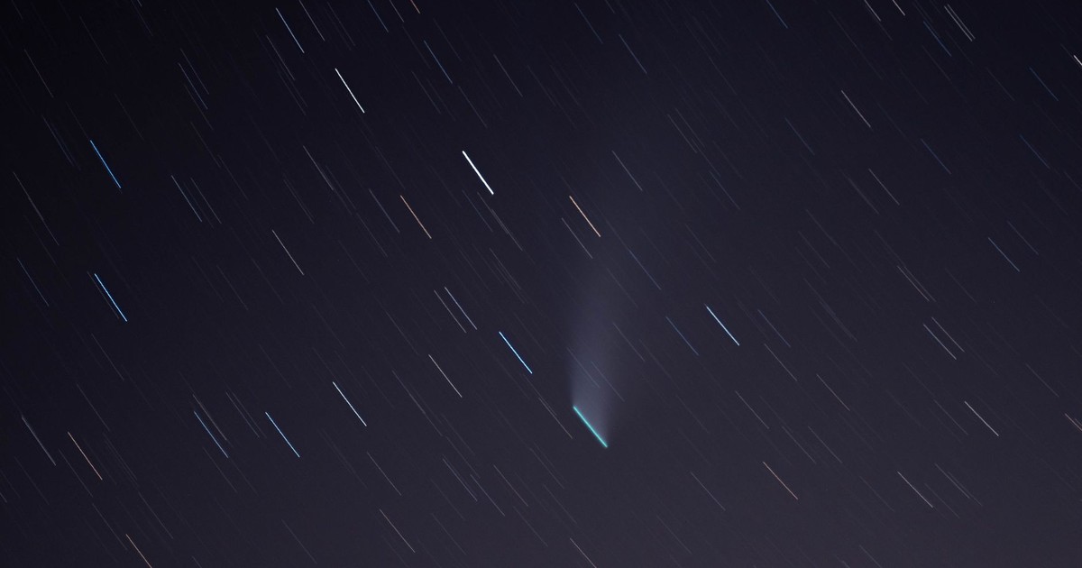 Long exposure of star trails and a comet illuminating the night sky over Airolo, Switzerland.
