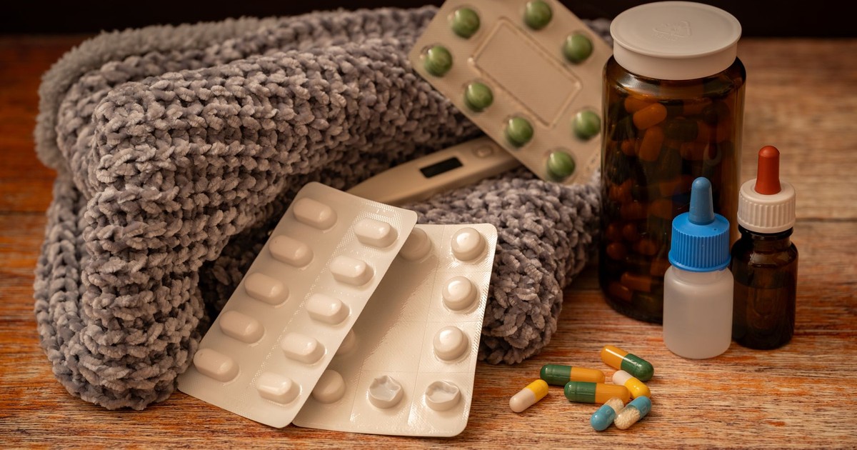 Warm indoor setup with medicine, scarf, and thermometer, ideal for cold and flu remedies.