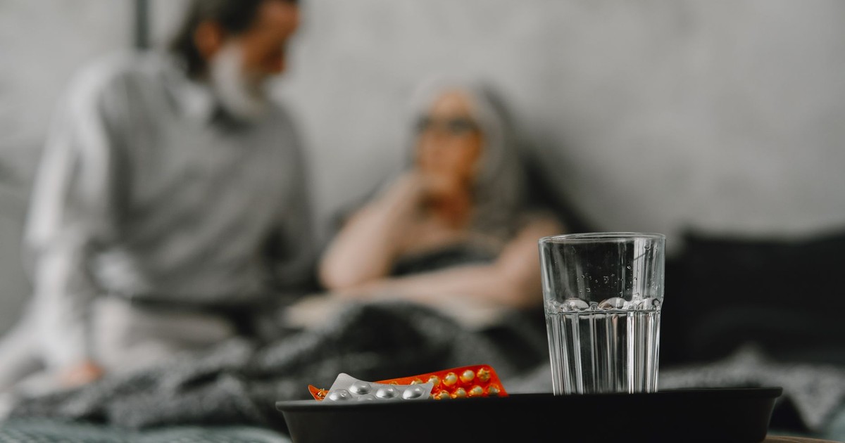 Elderly couple focuses on health support in a home setting with medications.
