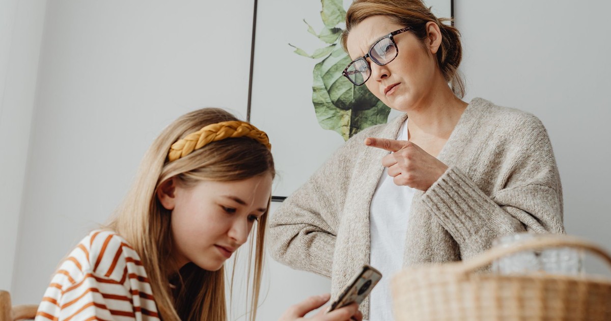 A mother scolds her teenage daughter for excessive phone use at home.