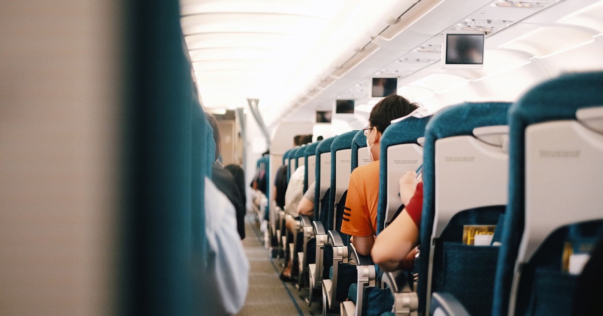 Interior view of airplane cabin showing passengers seated during a flight.