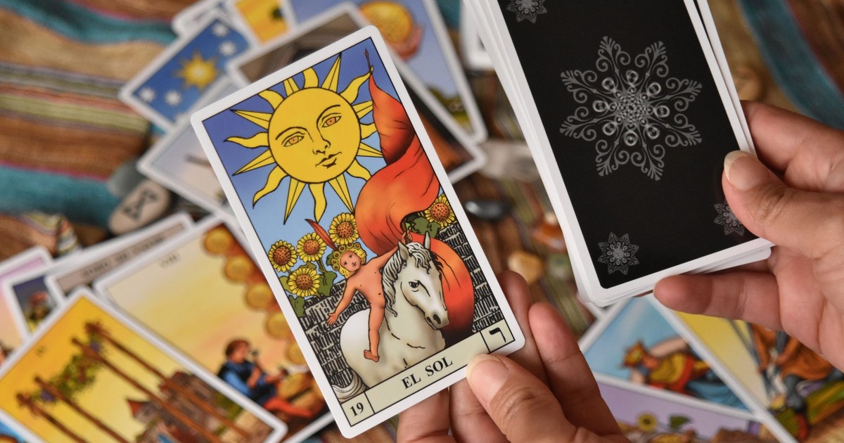 A detailed tarot card reading session featuring the 'El Sol' card with vibrant colors and mystical symbolism.