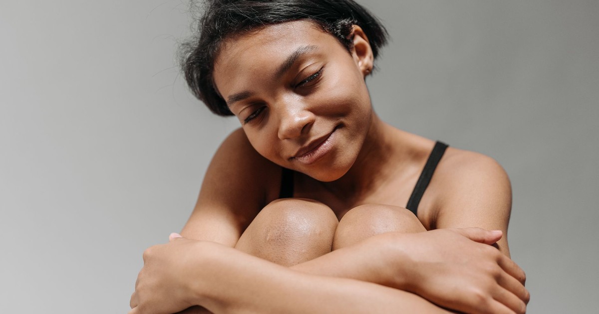 Close-up portrait of a young black woman with eyes closed, looking serene and content.