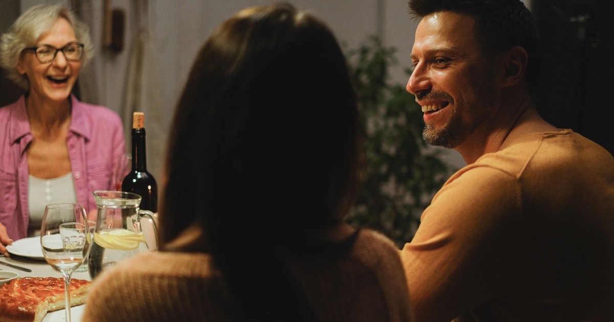 A joyful family sharing a dinner and engaging in warm conversation indoors.