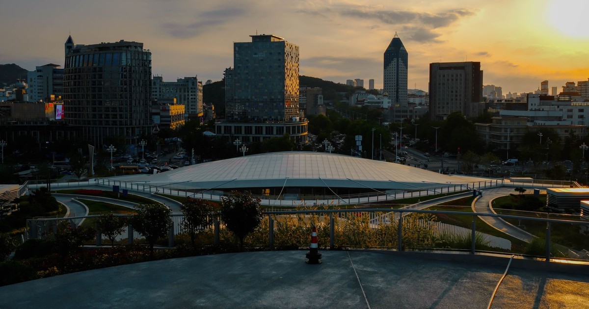 Urban landscape photo capturing modern buildings at sunset, featuring a unique dome structure.