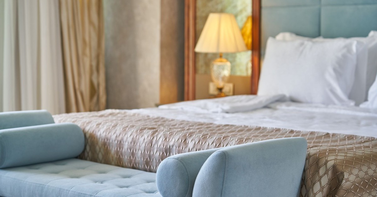Elegant bedroom interior featuring plush bed and seating with cozy ambiance lighting.