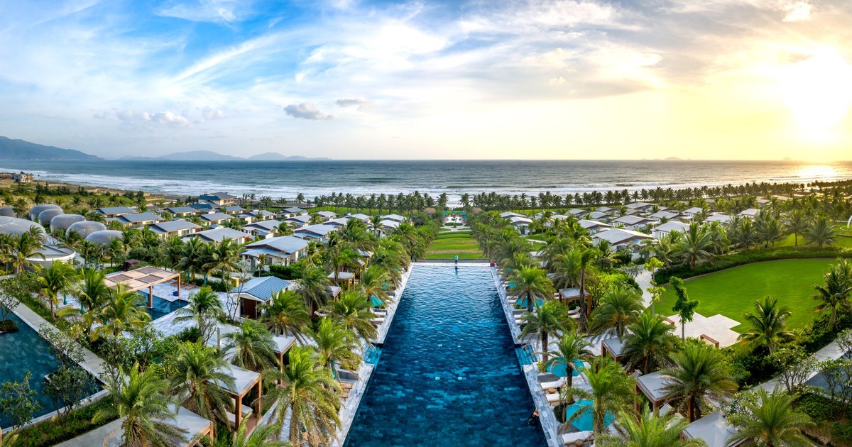 Discover a stunning beach resort with lush gardens and infinity pool overlooking the ocean at sunset.