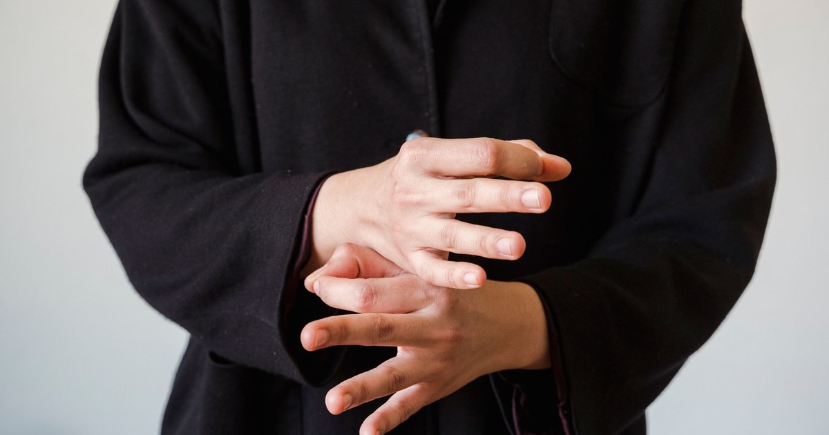 Close-up of hands gesturing in sign language on a white background.