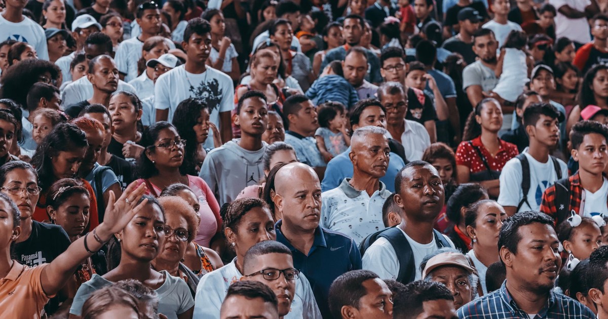 A large, diverse crowd gathers outdoor, showcasing unity and community spirit.