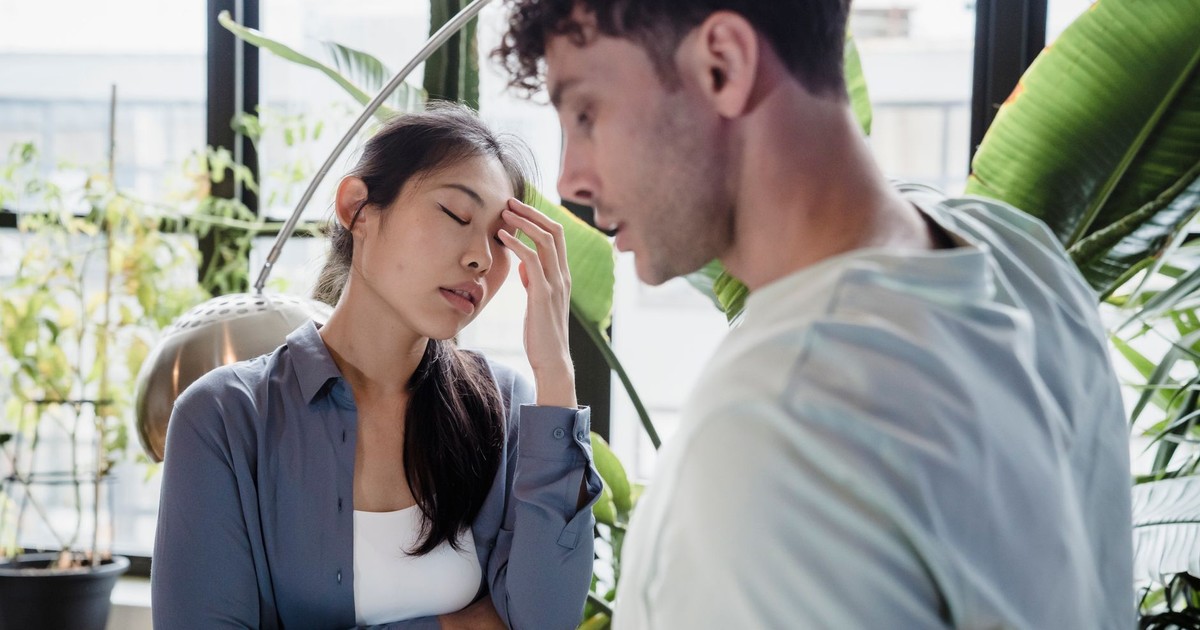 A couple experiencing a tense moment surrounded by plants in a modern space.