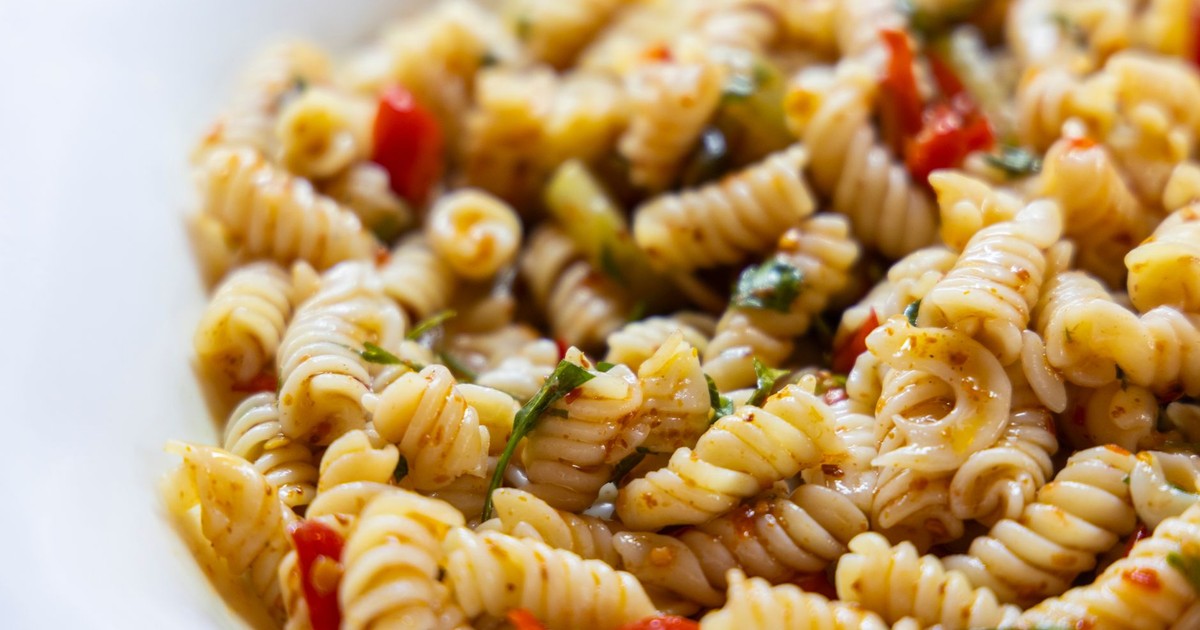 Close-up of a vibrant vegan rotini pasta salad with fresh vegetables.