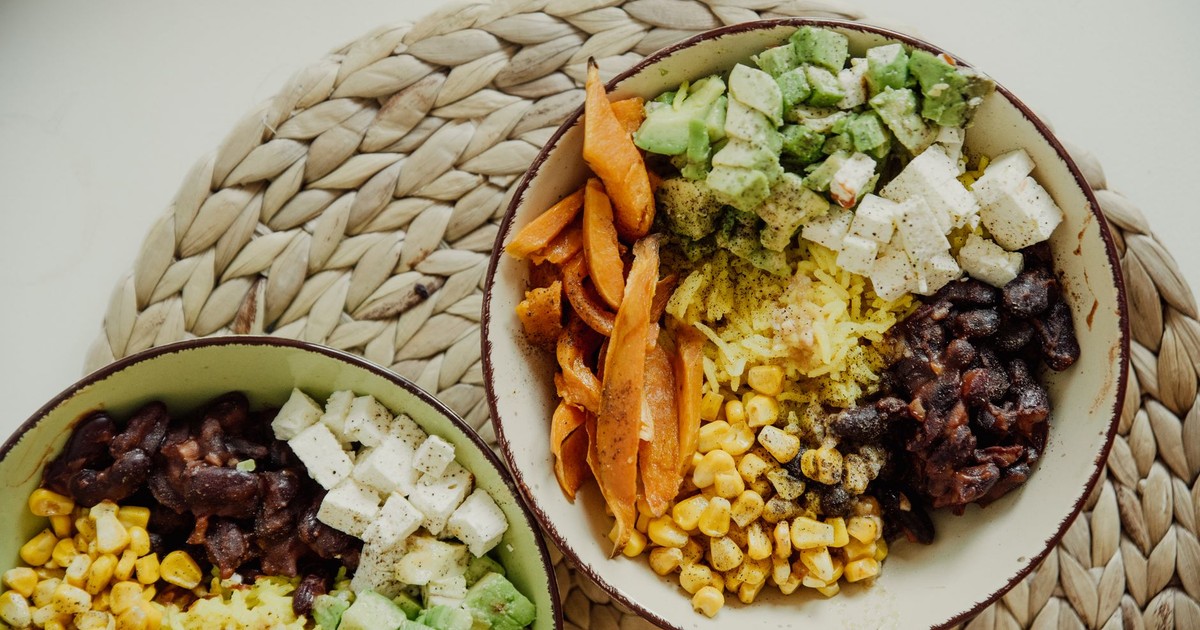 Top view of vegetarian bowls with avocado, corn, beans, and cheese for a delicious meal.