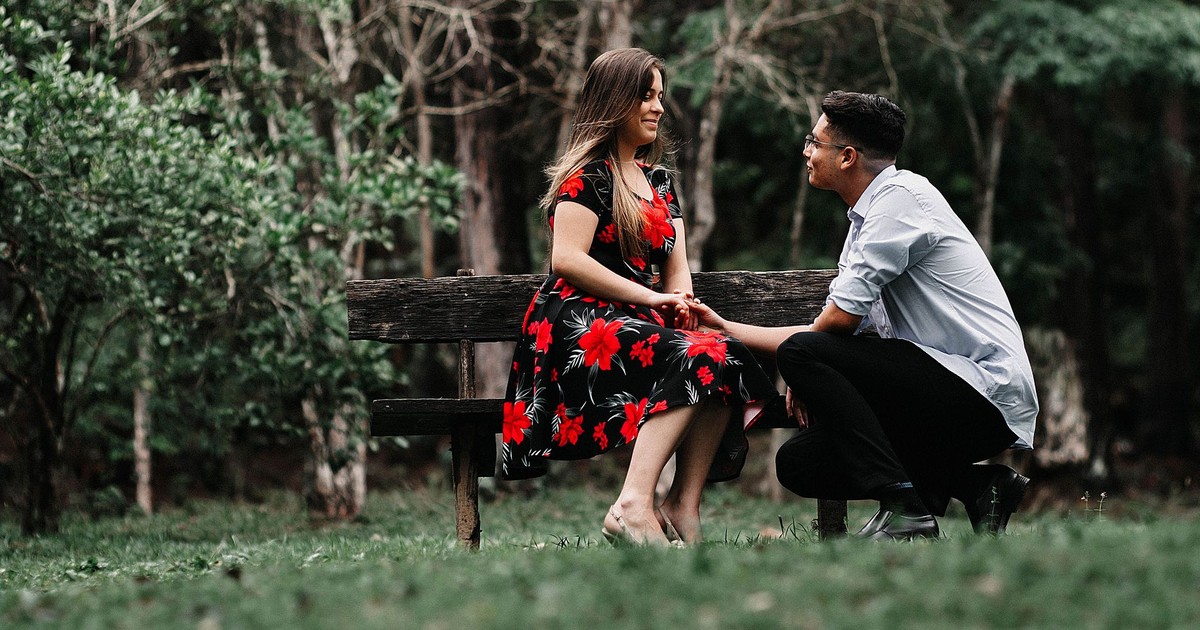 A man proposes to his partner in a tranquil park, creating a moment of joy and love.
