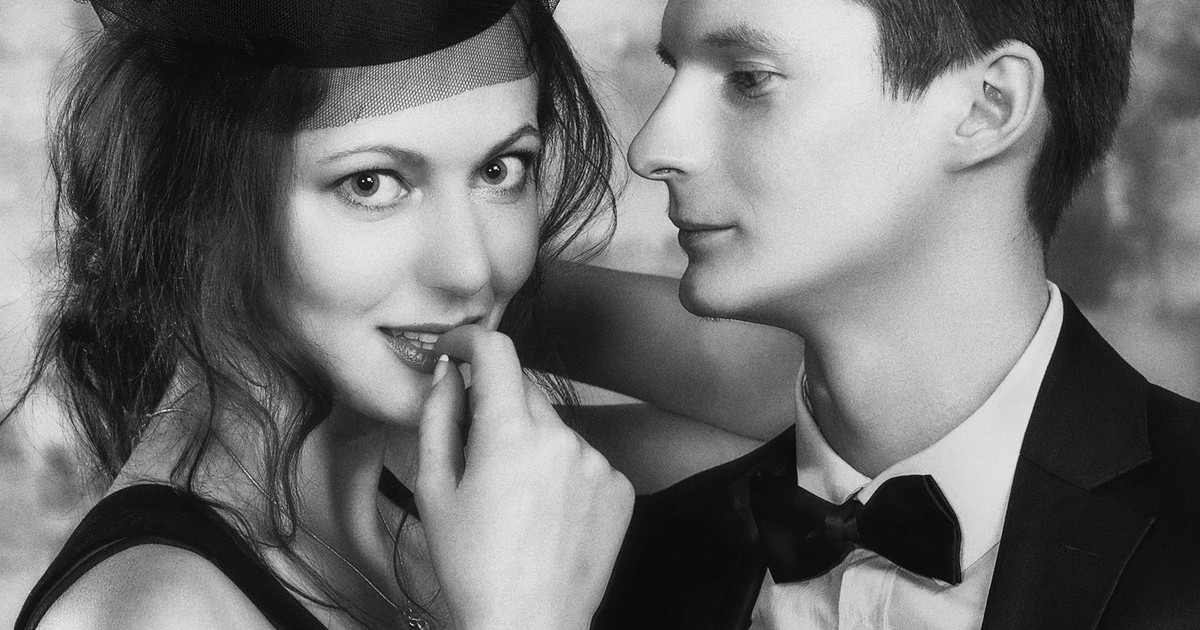 A classic black and white portrait of an elegant couple dressed in formal attire.