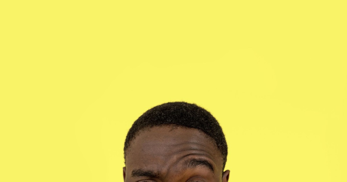 Close-up of a man's face with a thoughtful expression against a yellow background, offering ample space for text.