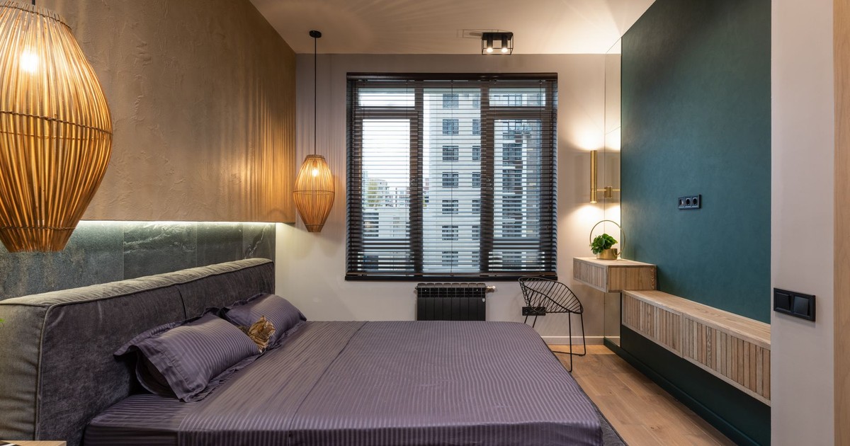 A stylish modern bedroom featuring luxurious decor, ambient lighting, and a city view through the window.
