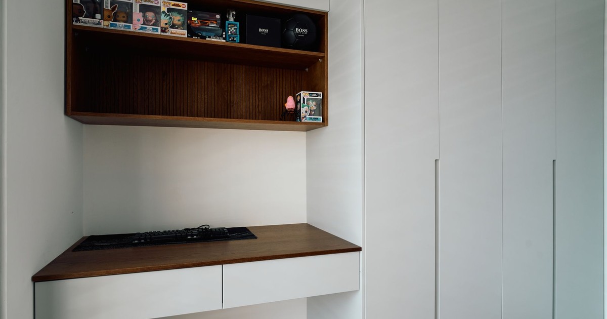 Modern white desk setup with collectibles, ideal for minimalist home office inspiration.