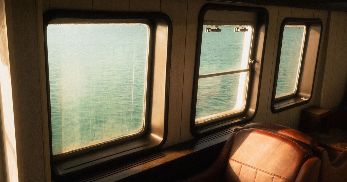 Tranquil view through ferry windows capturing İzmir's beautiful seaside.