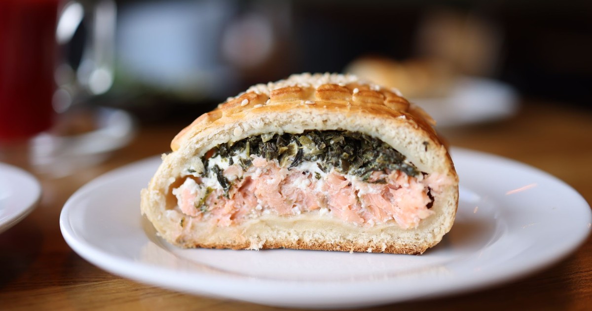 Close-up of salmon Wellington sliced on a plate with flaky pastry crust.