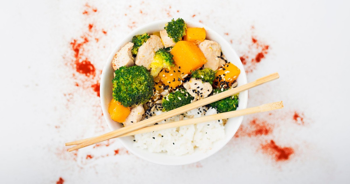 A delicious Asian-inspired chicken bowl with vegetables, rice, and spices.