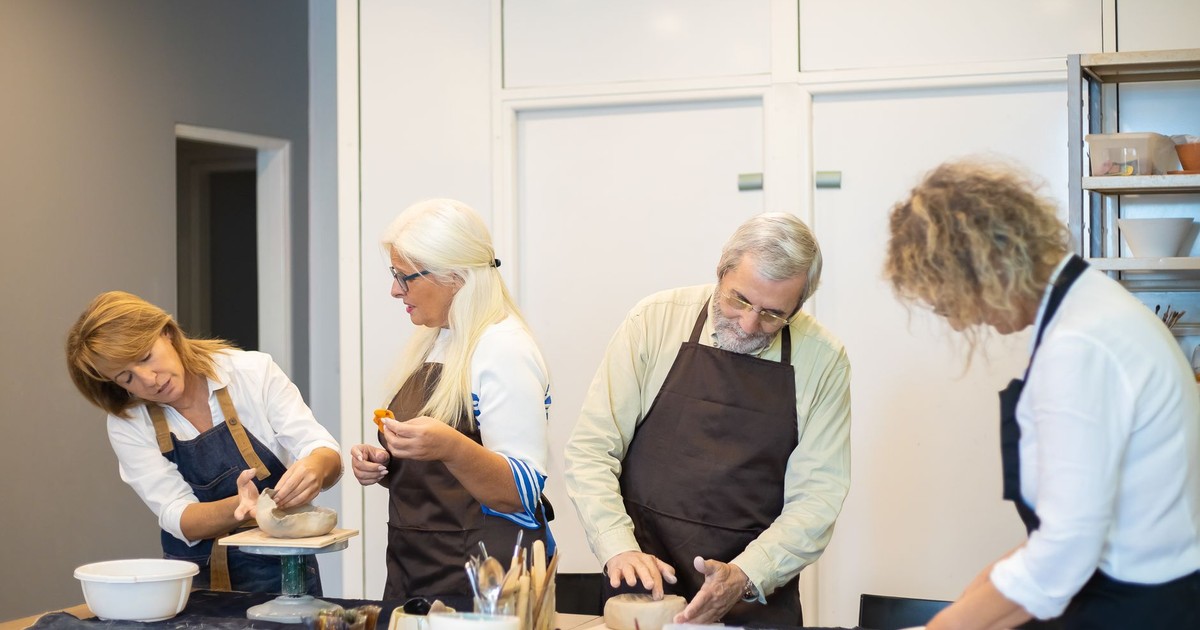 People engaged in a pottery workshop, crafting bowls indoors in Portugal.