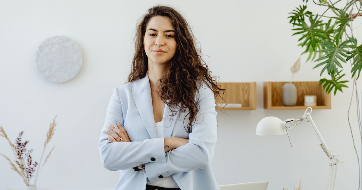 Professional woman with curly hair exuding leadership in a contemporary office environment.