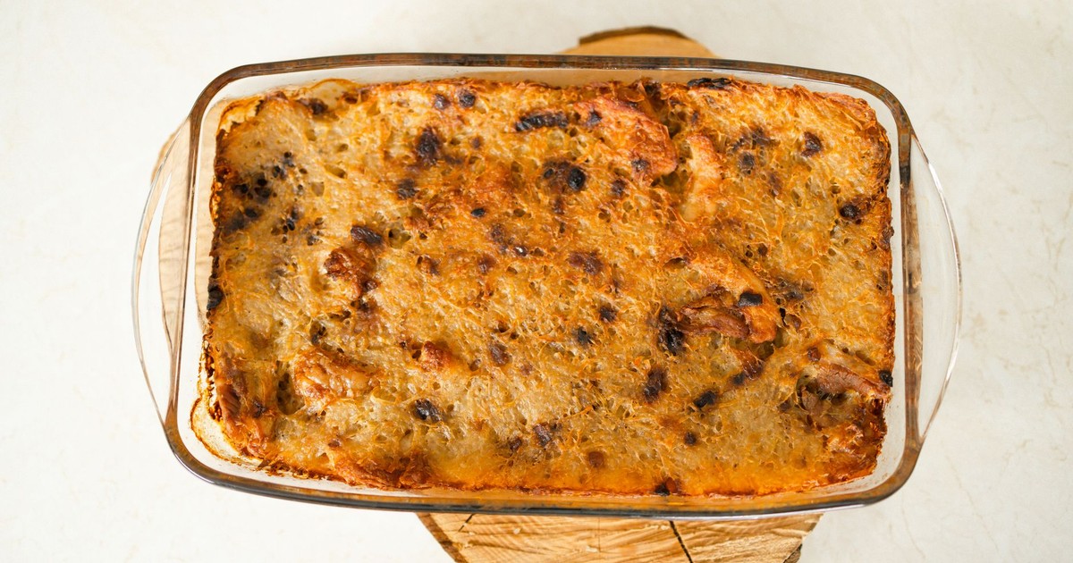 Top view of a freshly baked casserole in a glass dish on a wooden board.