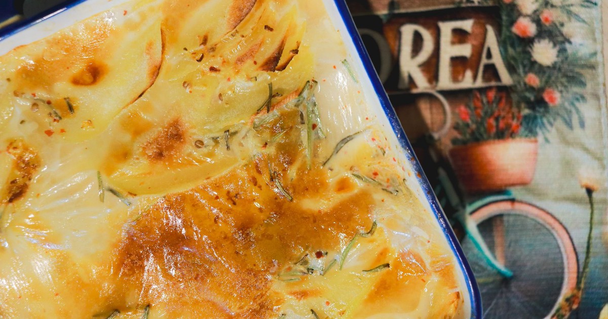 A rich and creamy potato gratin freshly baked, golden and crispy in a ceramic dish.
