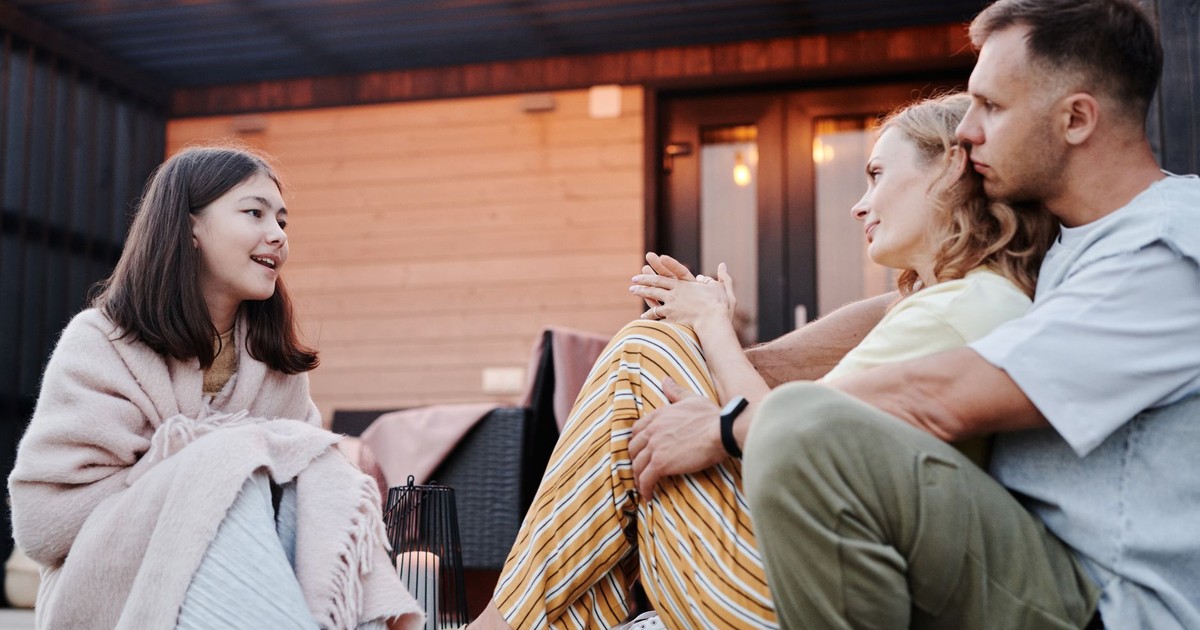 Family enjoying a warm conversation on a cozy patio in the evening.
