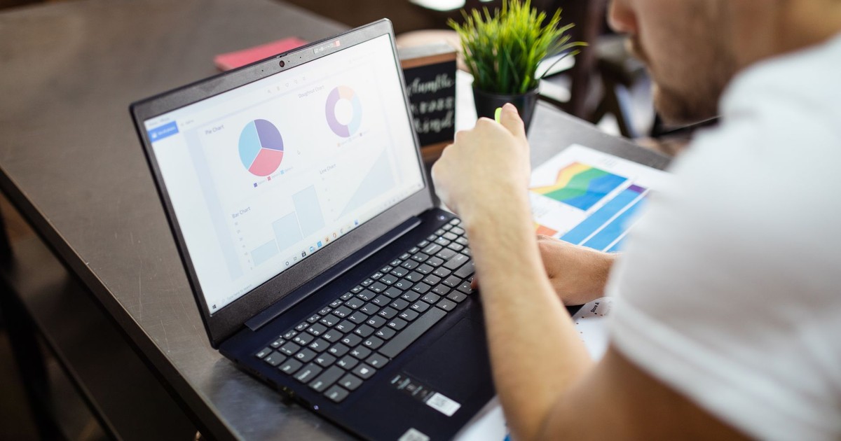 Man reviewing charts and graphs on a laptop for business analysis.