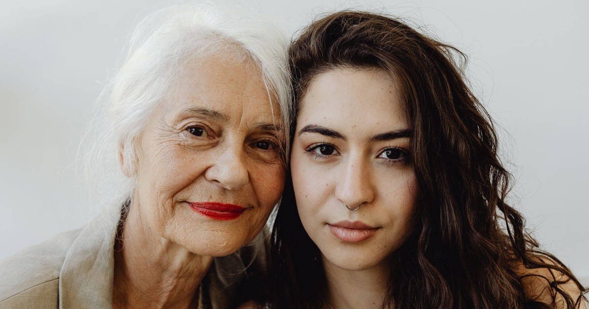 Elegant portrait of a grandmother and granddaughter looking directly at the camera, capturing their bond.