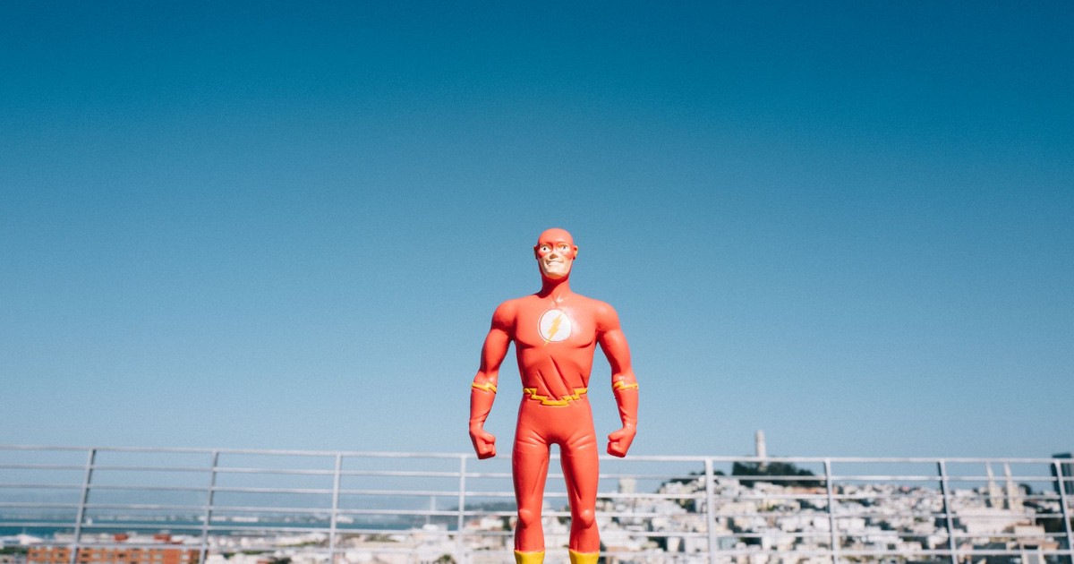 Toy superhero figurine with San Francisco skyline in background on a sunny day.