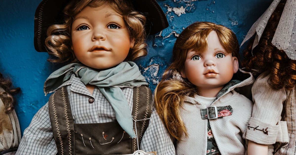 Charming vintage porcelain dolls dressed in rustic attire, perfect for collectors.
