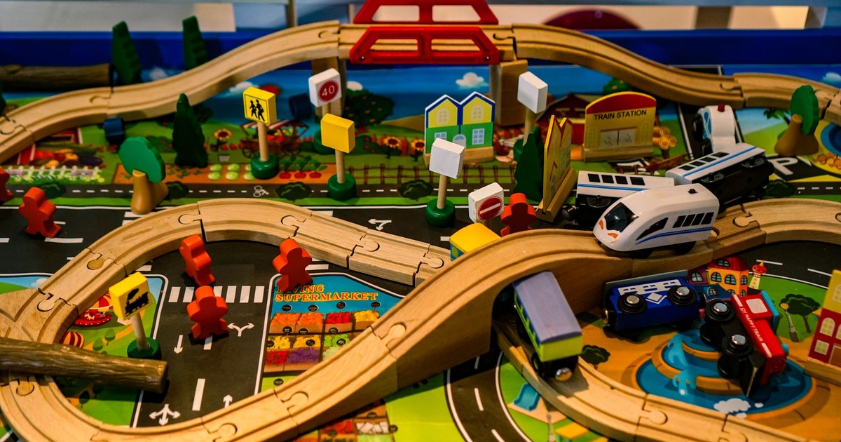 Vibrant and detailed wooden toy train set with roads, bridges, and signs for imaginative play.