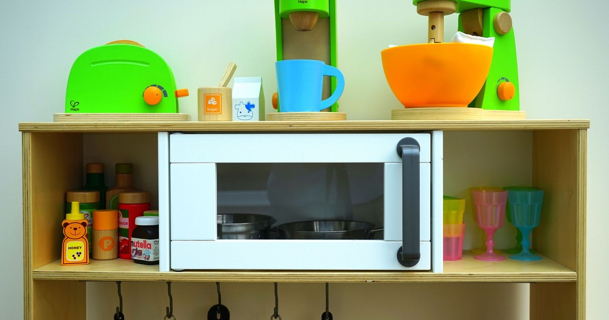 Vibrant children's toy kitchen set featuring wooden appliances and utensils, perfect for imaginative play.