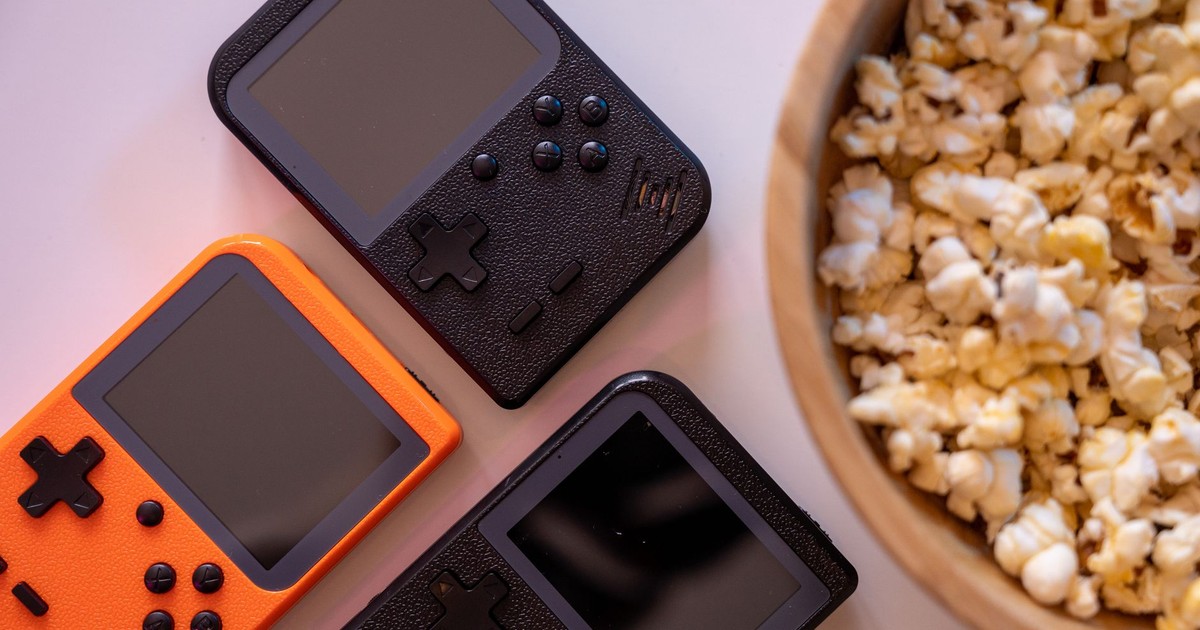 Close-up of retro handheld game consoles and popcorn, perfect for gaming nights.