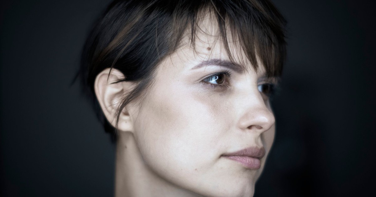 Young contemplative female with pure skin and dimple on chin with bang looking away