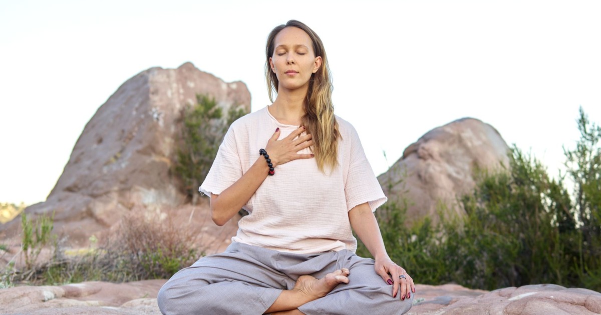 Woman meditating outdoors with closed eyes, embodying peace and relaxation.