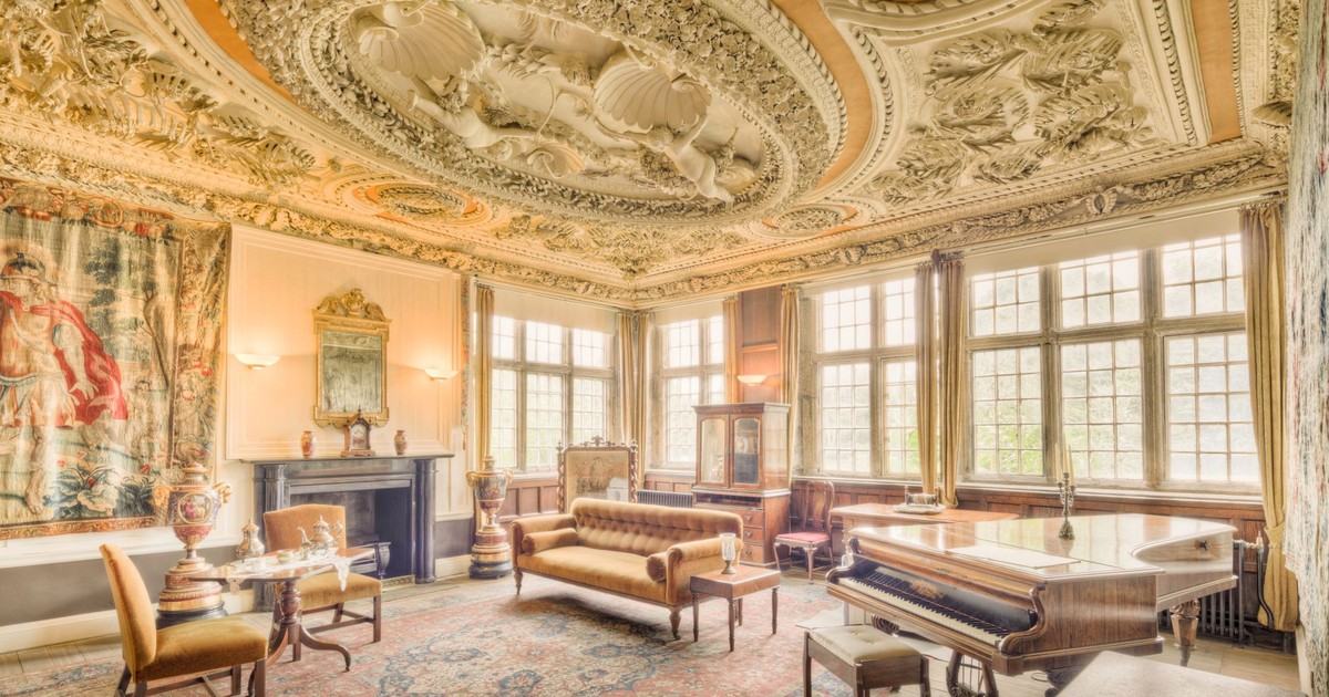 Explore an exquisite Regency-style drawing room with luxurious furniture and elaborate ceiling design in England.