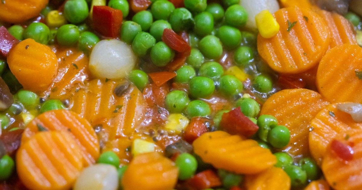Vibrant close-up of mixed vegetables including carrots and peas in a stew.
