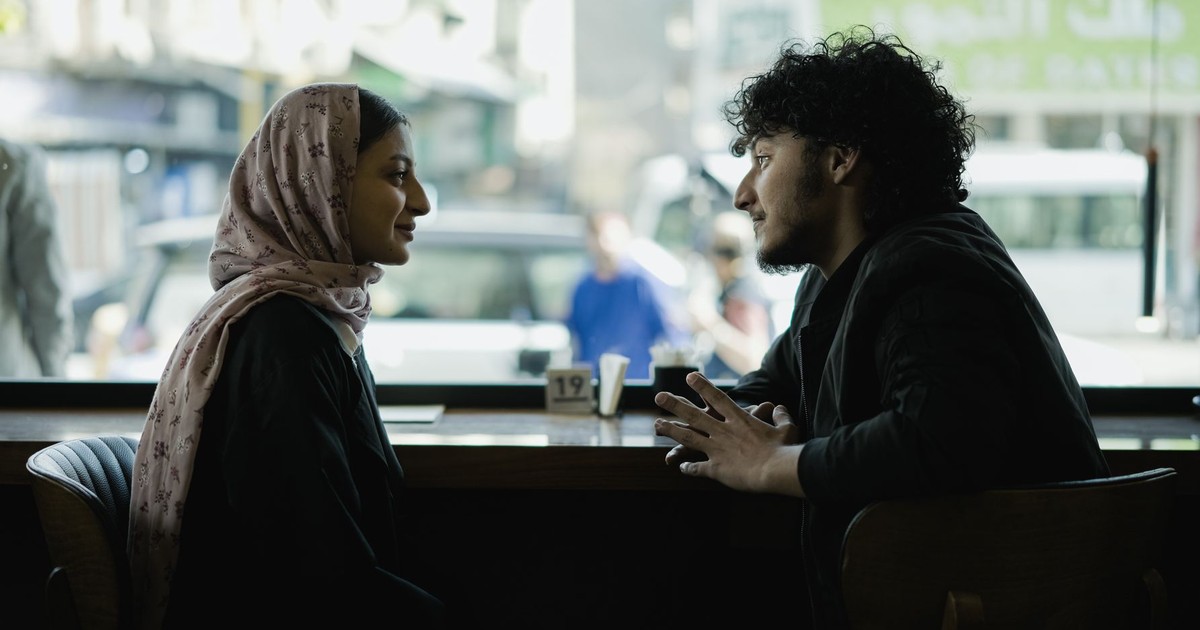 A candid moment of two adults engaging in conversation at a café.