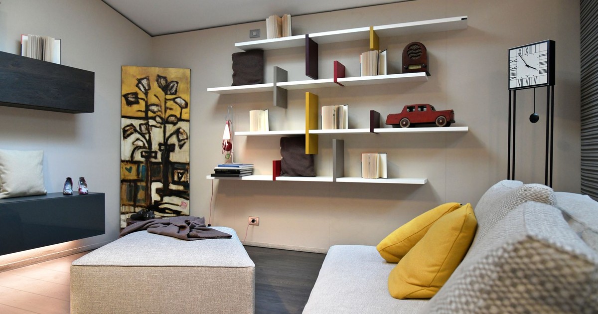 Chic and cozy Italian living room featuring modern shelving and artistic elements.