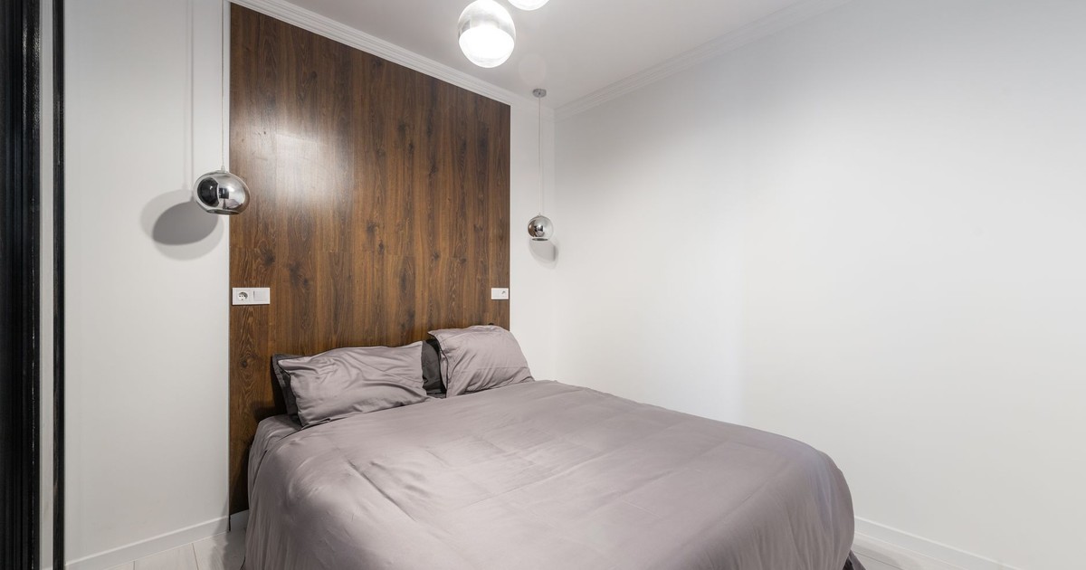 Contemporary bedroom with sleek design, wooden accents, and pendant lights.